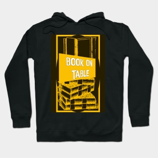 Book of table yellow and black designed totes, phone cases, mugs, masks, hoodies, notebooks, stickers pins, Hoodie